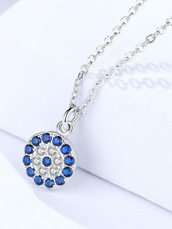 Silver necklace with a blue gemstone pendant on a white background