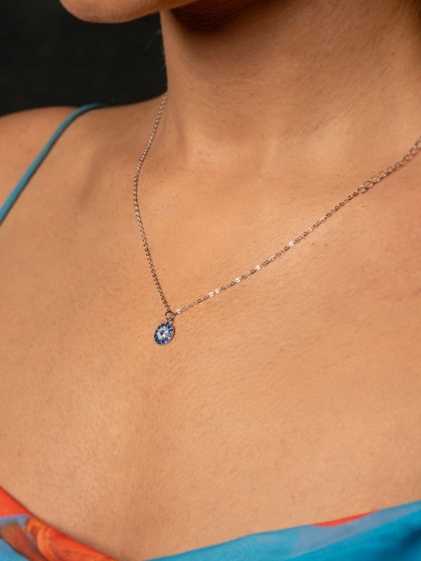 Necklace with a blue pendant worn by a woman.