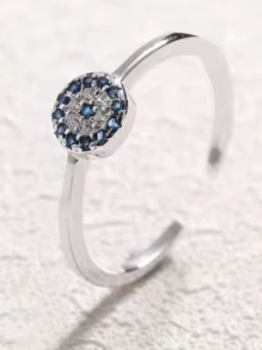 Silver ring with a blue gemstone on a textured white background