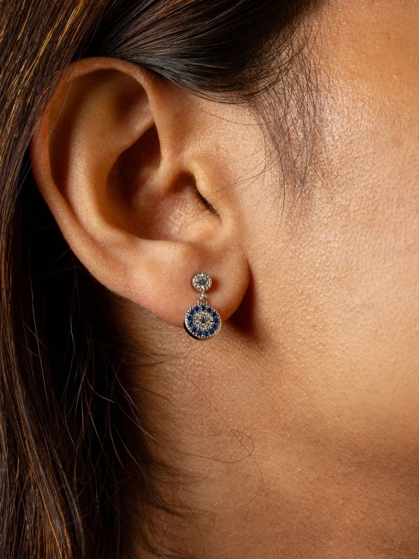 Close-up of an ear wearing a blue and silver earring.