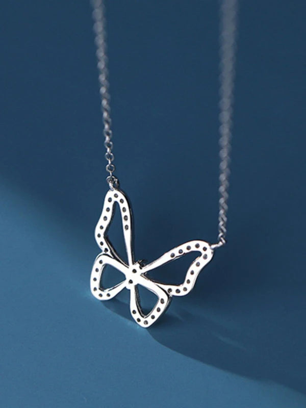 Butterfly-shaped pendant on a chain against a blue background