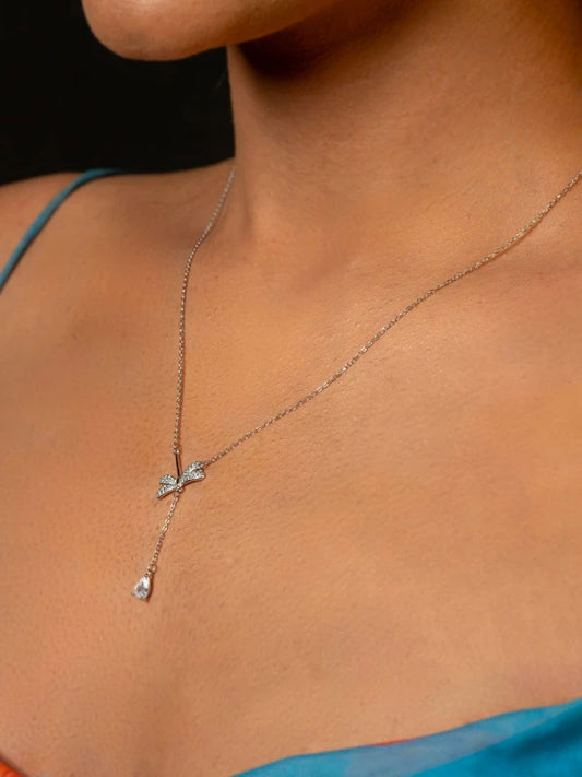 Necklace with a pendant on a person wearing a blue top.