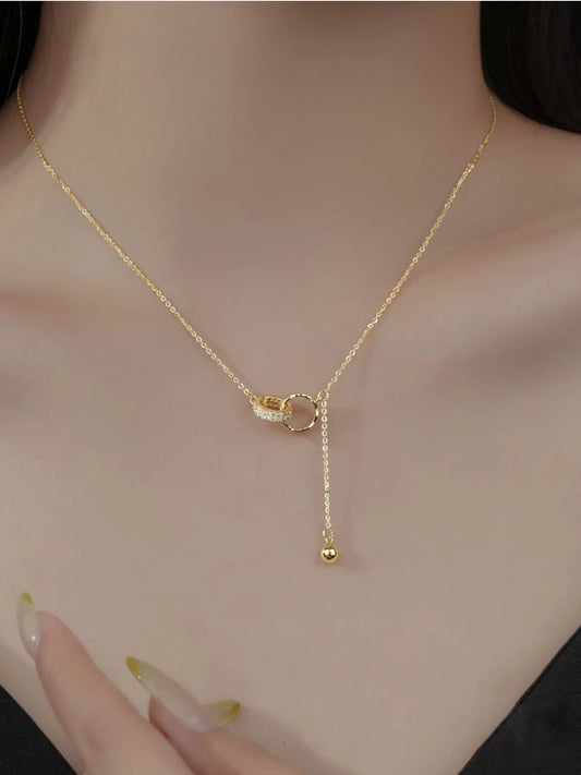 Gold necklace with a delicate pendant on a woman's neck