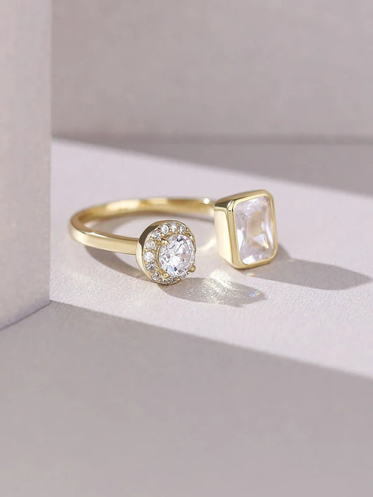 Gold ring with two distinct gemstones on a light background