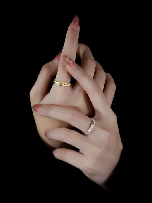 Hand with gold and silver rings on a black background