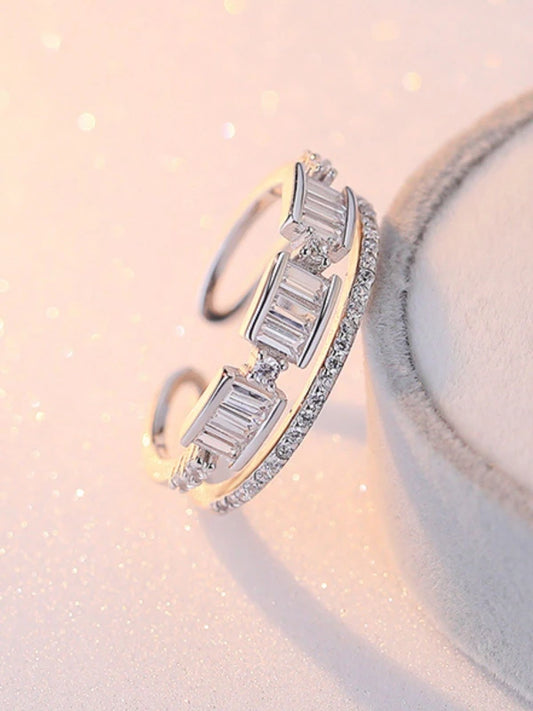 Silver ring with baguette cut diamonds on a soft pink background