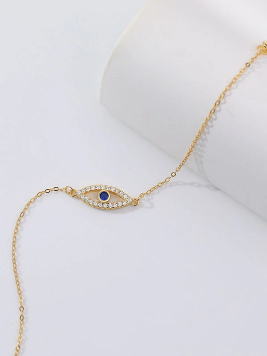 Gold necklace with a blue gemstone on a white background