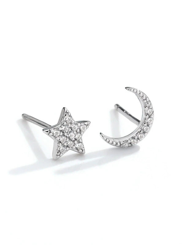Silver star and moon earrings on a white background