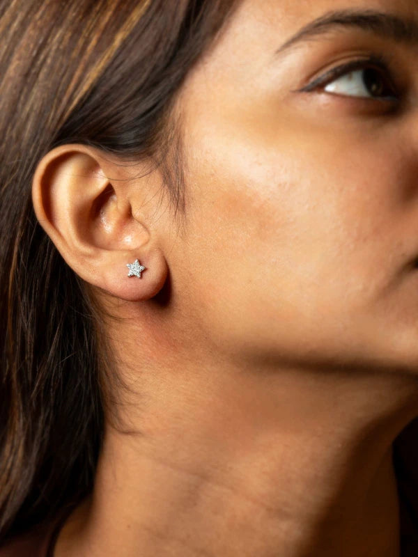 Close-up of a person wearing a star-shaped earring.