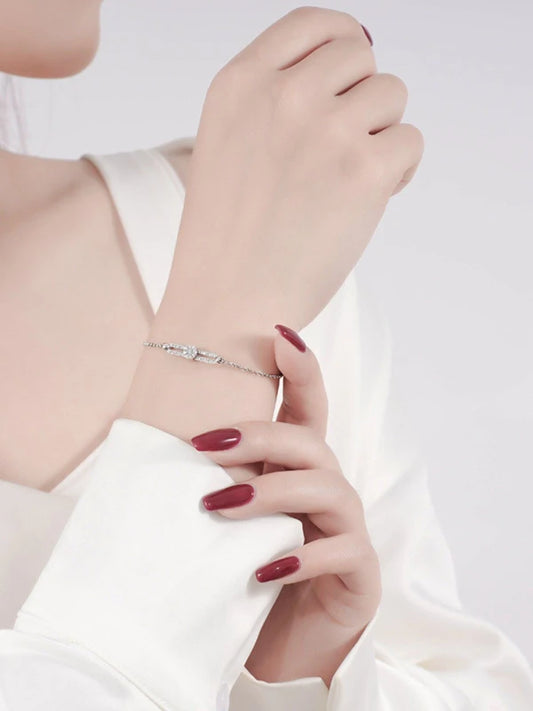 Hand wearing a silver bracelet on a white background