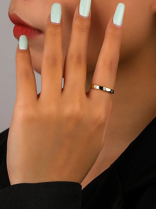 Close-up of a hand with a ring on a neutral background