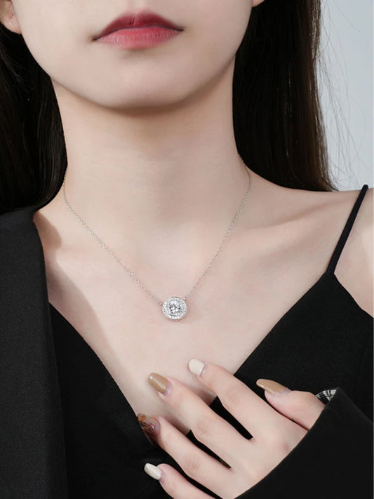 Close-up of a woman wearing a delicate necklace with a diamond pendant.