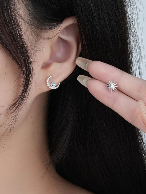 Close-up of a woman wearing a silver earring with a blue gemstone.