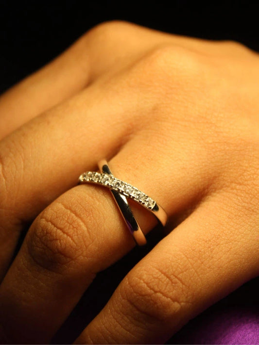 Close-up of a hand wearing a diamond ring with a dark background