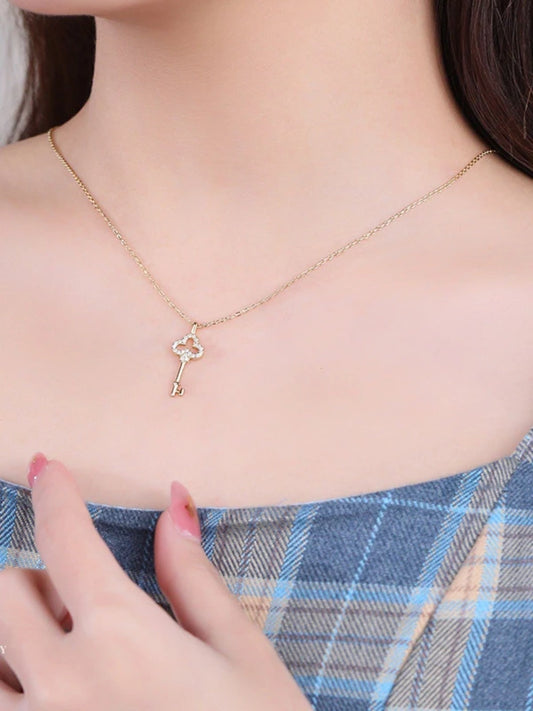 Necklace with a key-shaped pendant worn by a woman.