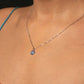 Necklace with a blue pendant worn by a woman.