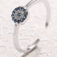 Silver ring with a blue gemstone on a textured white background