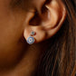 Close-up of an ear wearing a diamond earring with a blurred background