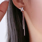 Butterfly earrings with a dangling design worn by a person with long hair.