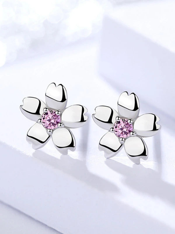 Silver earrings with pink gemstones on a white background