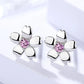 Silver earrings with pink gemstones on a white background