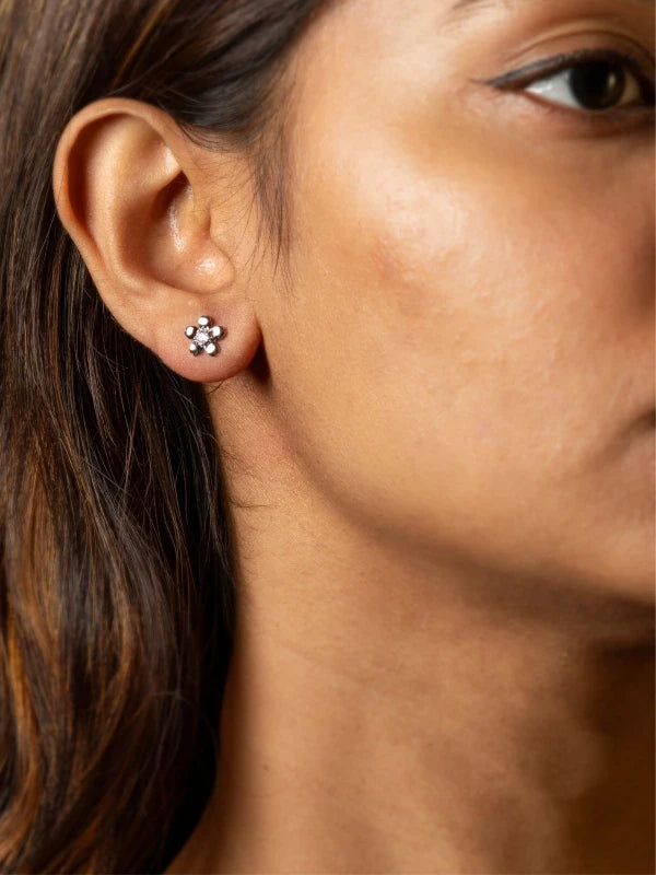 Close-up of a woman wearing a silver earring with a paw print design.