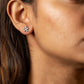 Close-up of a woman wearing a silver earring with a paw print design.