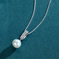 Pearl necklace with silver clasp on a teal background