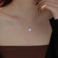 Silver four-leaf clover necklace worn by a woman.