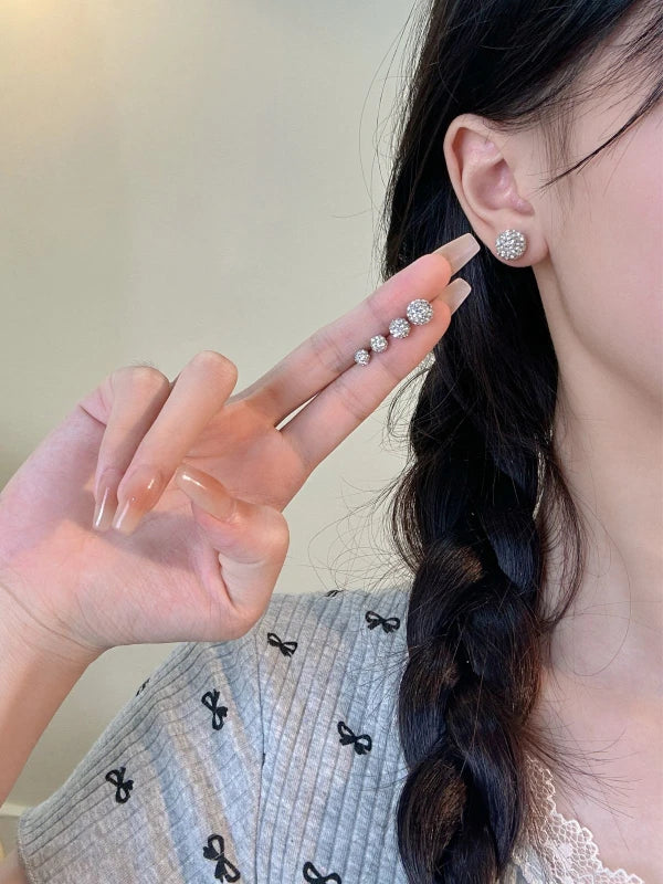 Woman wearing diamond earrings with a blurred background