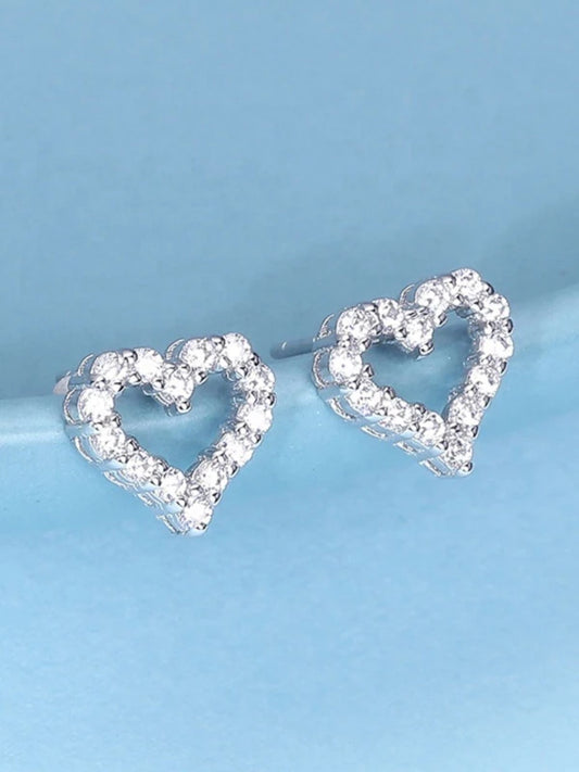 Heart-shaped earrings with clear gemstones on a light blue background