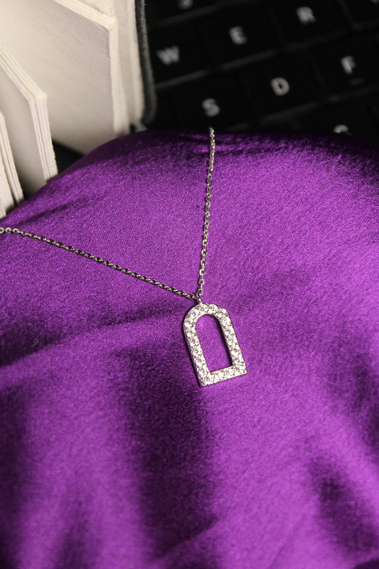 Necklace with a diamond-studded pendant on a purple fabric background
