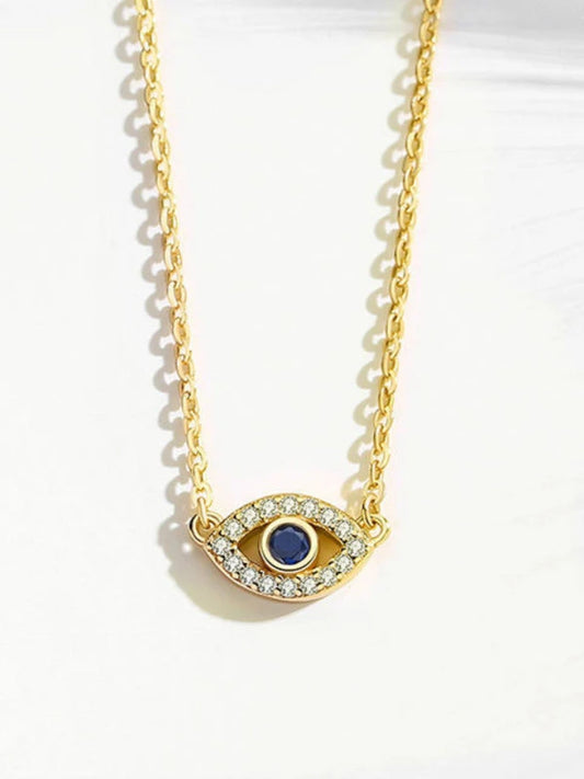 Gold necklace with an eye-shaped pendant featuring a blue gemstone on a white background