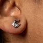 Close-up of an ear with a unique earring featuring a crescent moon and star design.