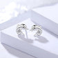 Silver dolphin-shaped earrings with clear gemstones on a white box