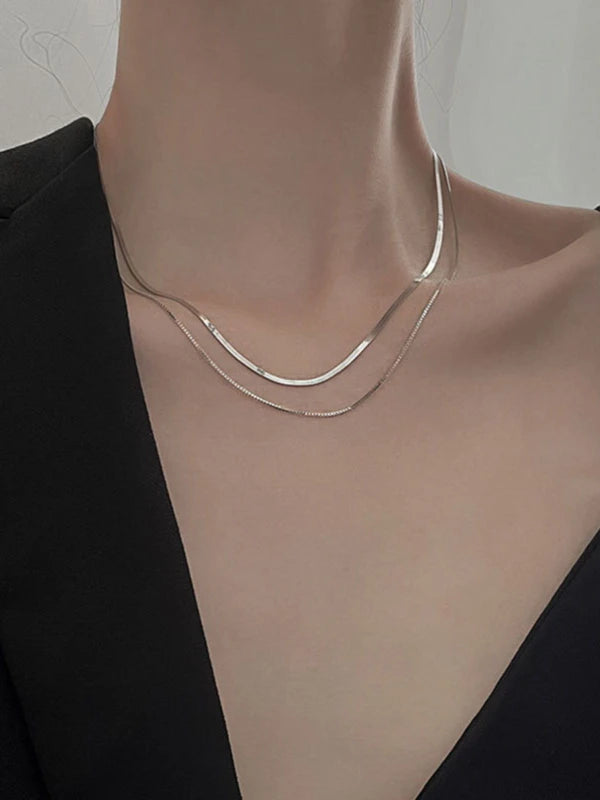 Silver necklace on a mannequin with a plain background