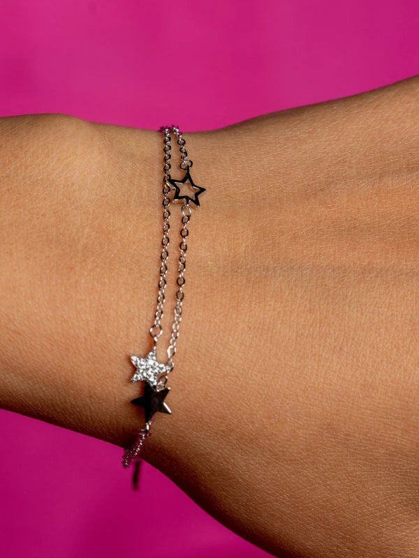 Star-shaped bracelet on a wrist with a pink background