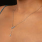 Necklace with a pendant on a person wearing a blue top.