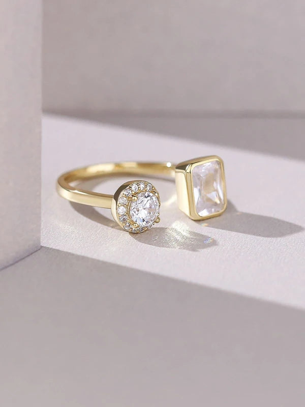 Gold ring with two distinct gemstones on a light background