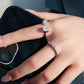 Hand wearing two diamond rings with a blurred background