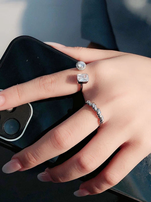 Hand wearing two diamond rings with a blurred background