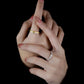 Hand with gold and silver rings on a black background
