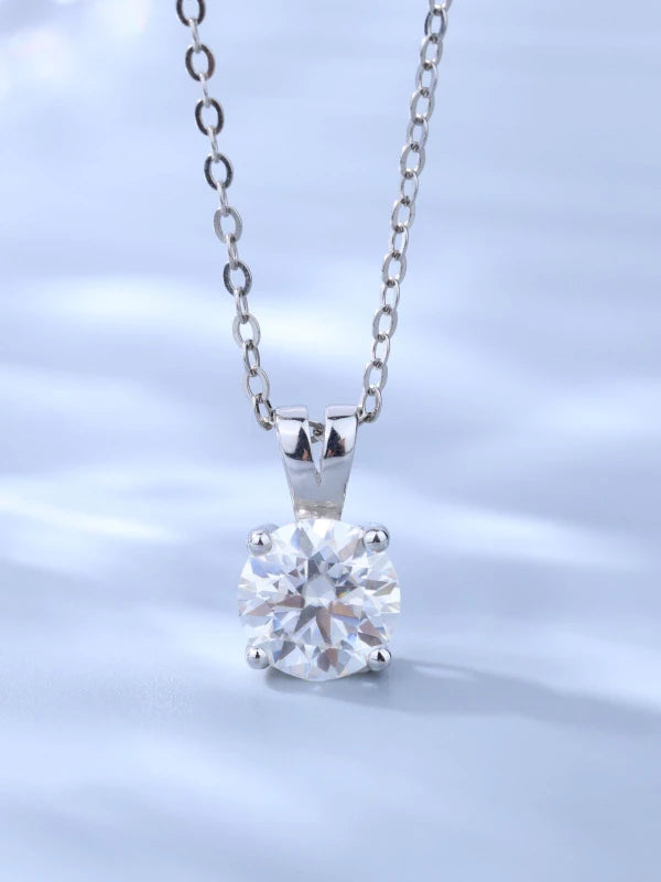 Silver necklace with a clear gemstone pendant on a light blue background
