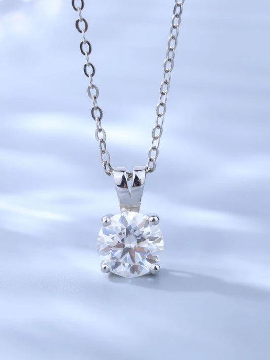 Silver necklace with a clear gemstone pendant on a light blue background