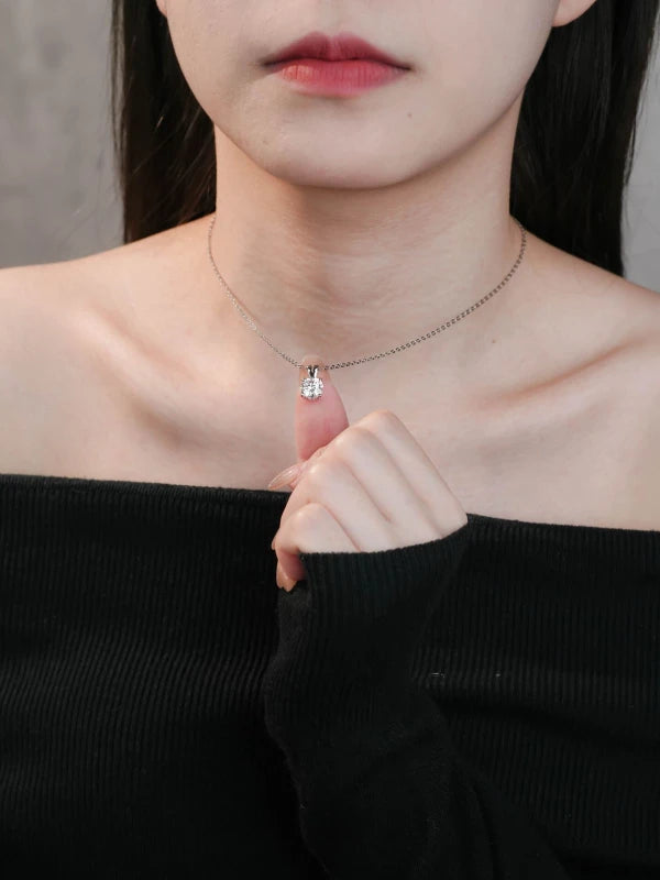 Woman wearing a delicate necklace with a small pendant
