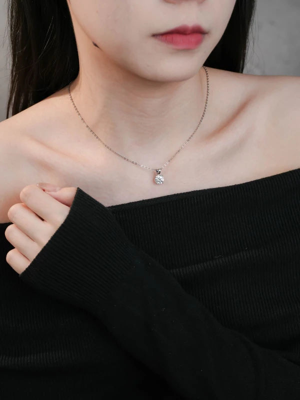 Person wearing a delicate necklace with a small pendant
