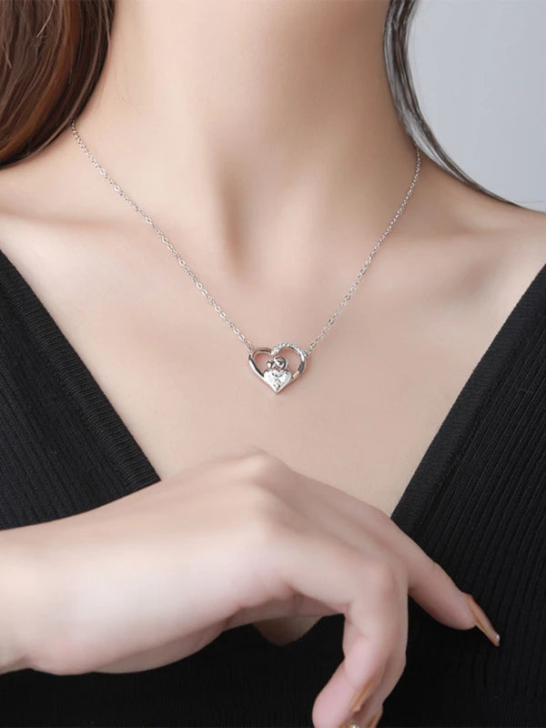 Heart-shaped necklace worn by a person with a blurred background