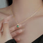 Gold necklace with a green gemstone pendant worn by a woman