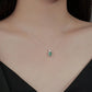 Necklace with a green gemstone pendant on a model wearing a black top.
