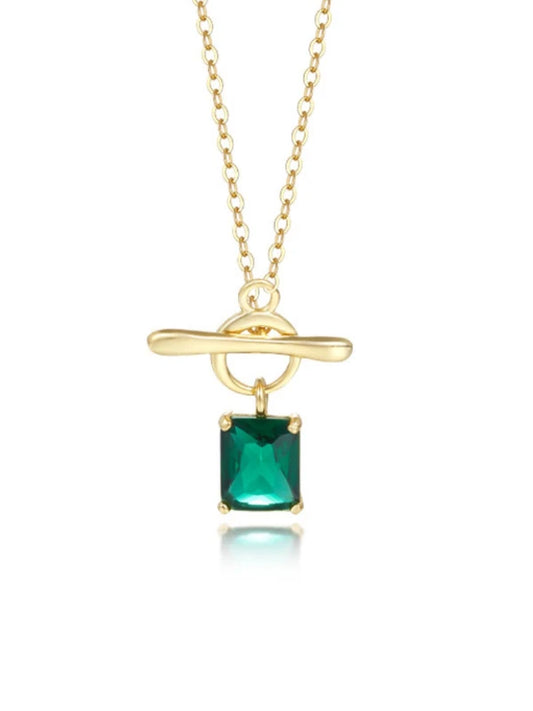 Gold necklace with a green gemstone pendant on a white background
